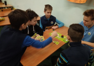 Pięciu chłopców gra w karty.