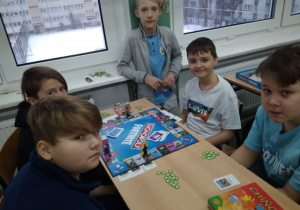 Pięciu chłopców grających w „Monopoly”.