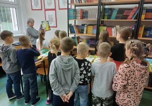 Uczestnicy świetlicy oglądają przygotowaną wystawkę książek w bibliotece szkolnej przygotowaną przez panią bibliotekarkę, Elżbietę Fer