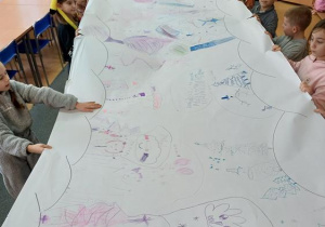 Uczniowie demonstrują wykonaną grupową pracę "Zimowe inspiracje"