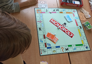 Uczniowie grają w grę "Monopoly".