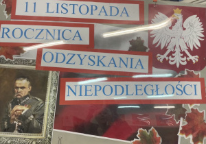 Tablica przedstawiająca symbole narodowe Polski z napisem 11 listopada Rocznica Odzyskania Niepodległości